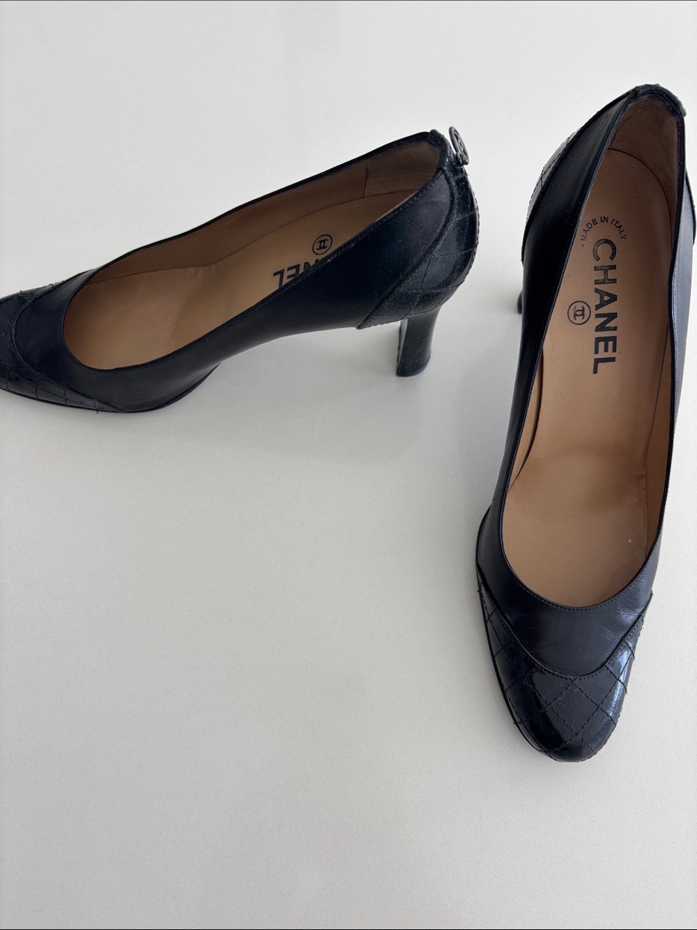Vintage Chanel pumps Black leather/patent leather. Chanel logo on back of shoe.